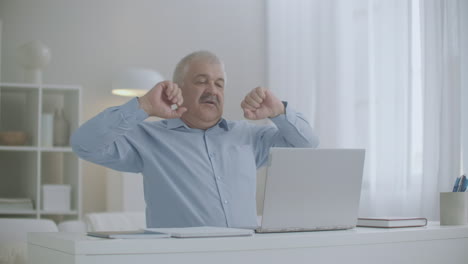 aged-man-is-stretching-hands-during-working-with-laptop-at-home-feeling-overextension-and-fatigue-of-muscles-feeling-bad-at-workplace